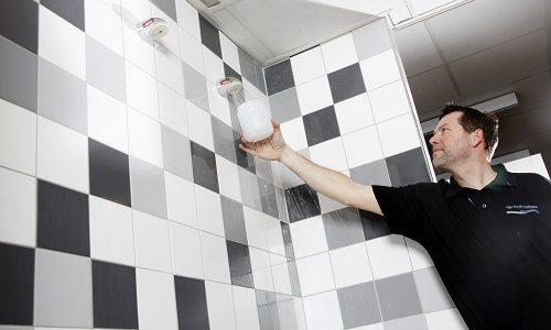 Medewerker Hydroscope voert spoelwerkzaamheden uit aan een douche