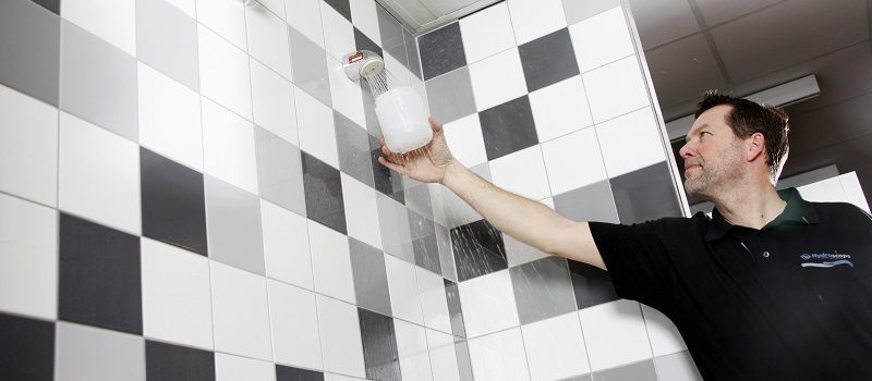 Medewerker Hydroscope voert spoelwerkzaamheden uit aan een douche